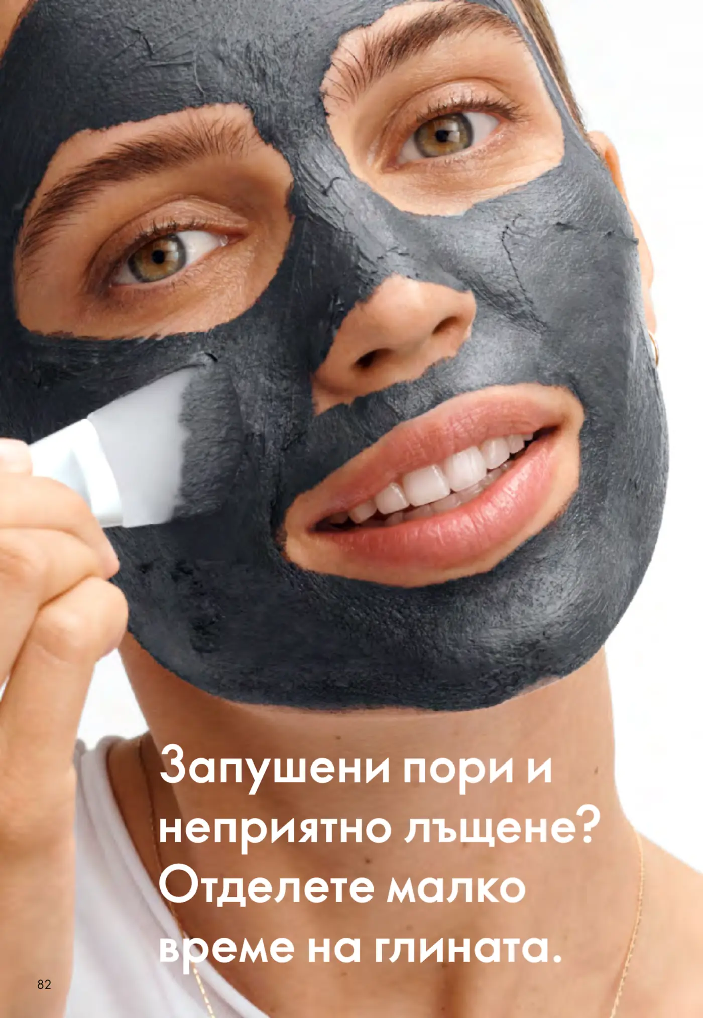 Млада жена нанася тъмносива глинена маска за лице с бяла четка, насочена към почистване на порите и намаляване на омазняването. Погледът ѝ е спокоен, а текстът на страницата пита: 'Запушени пори и неприятно лъщене? Отделете малко време на глината.'