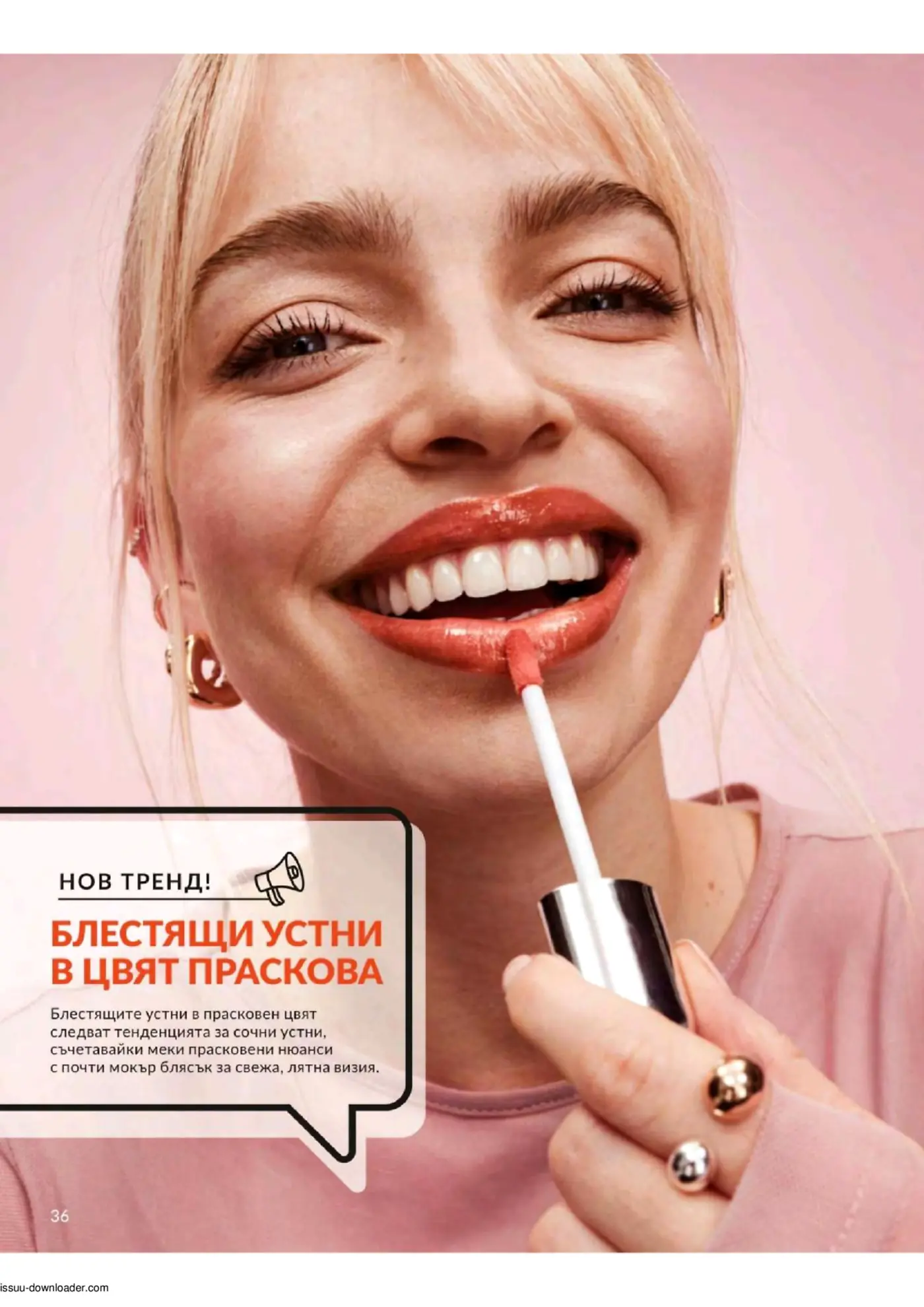Усмихната жена с руса коса нанася прасковен гланц за устни, демонстрирайки лъскави, сочни устни.